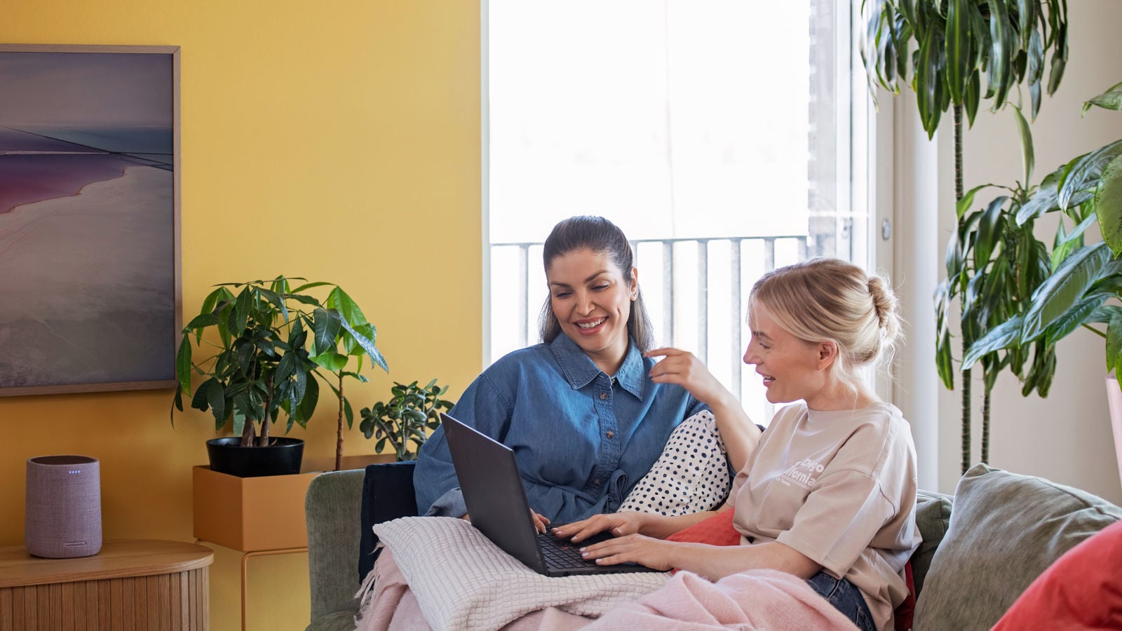 Two woman use computer