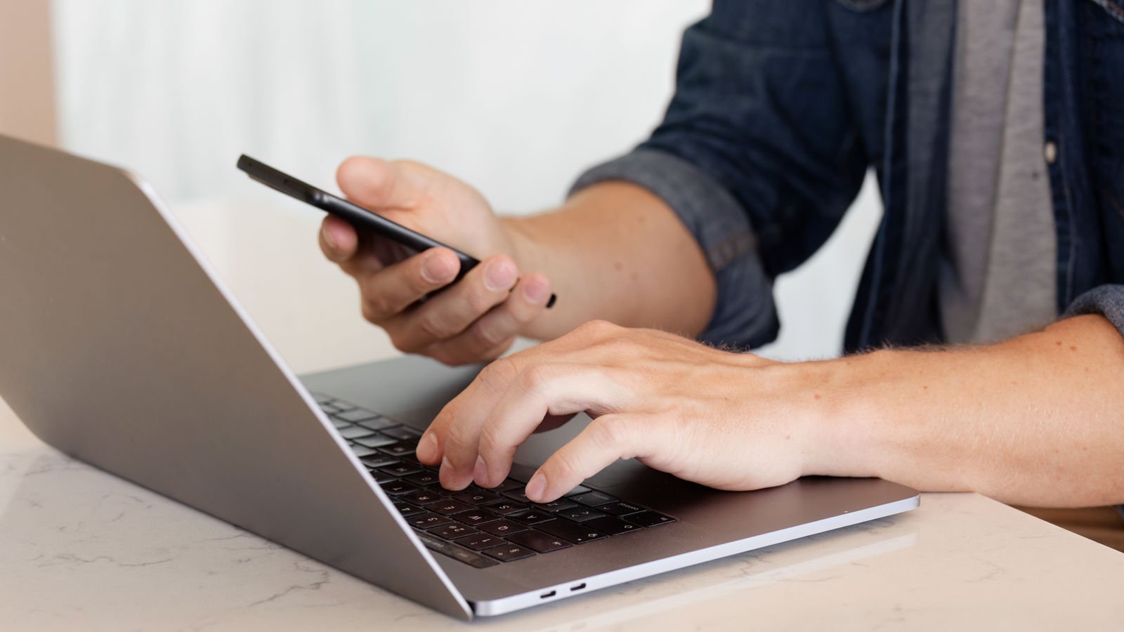 Man skriver på datorn.