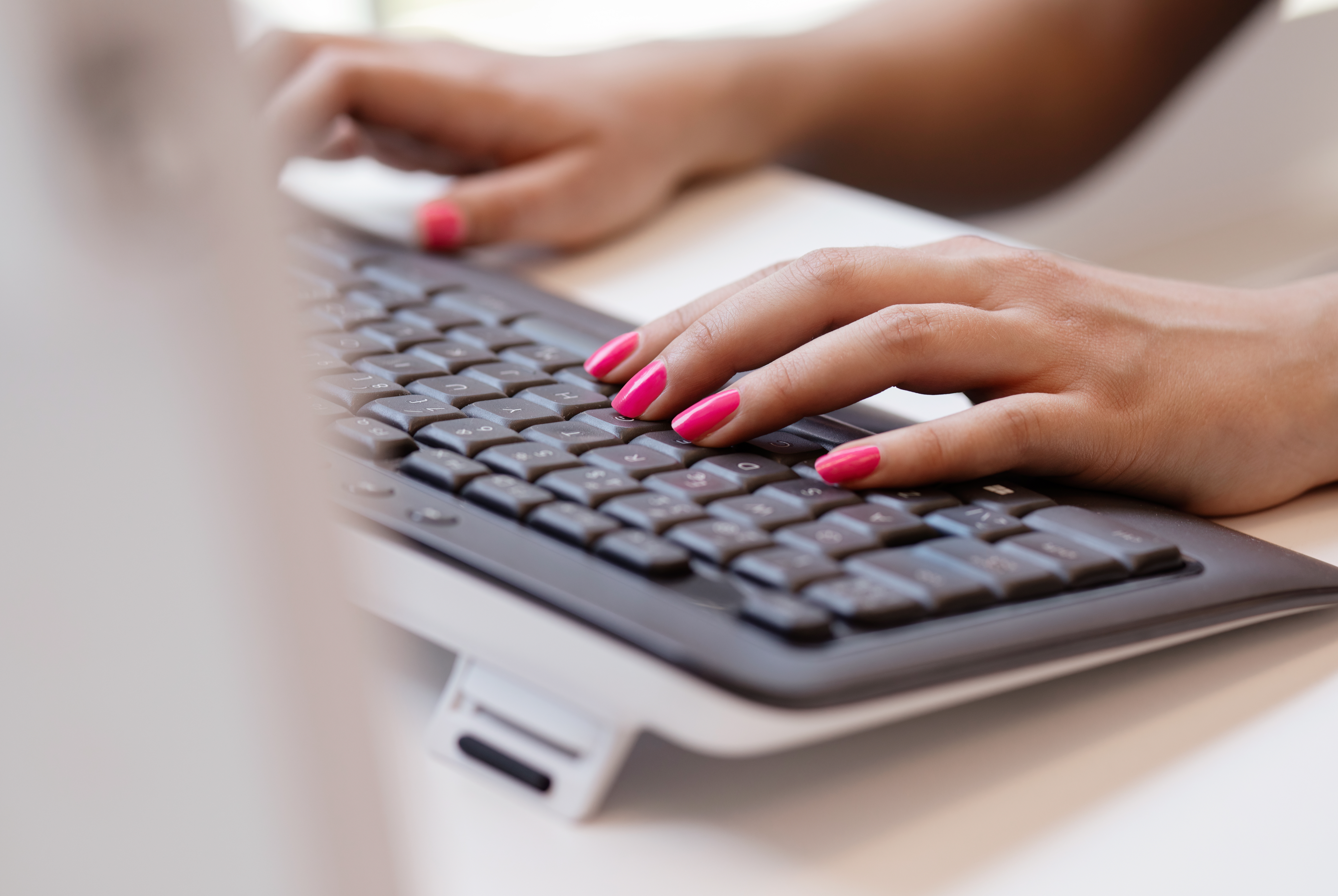 The woman’s hands on the keyboard.