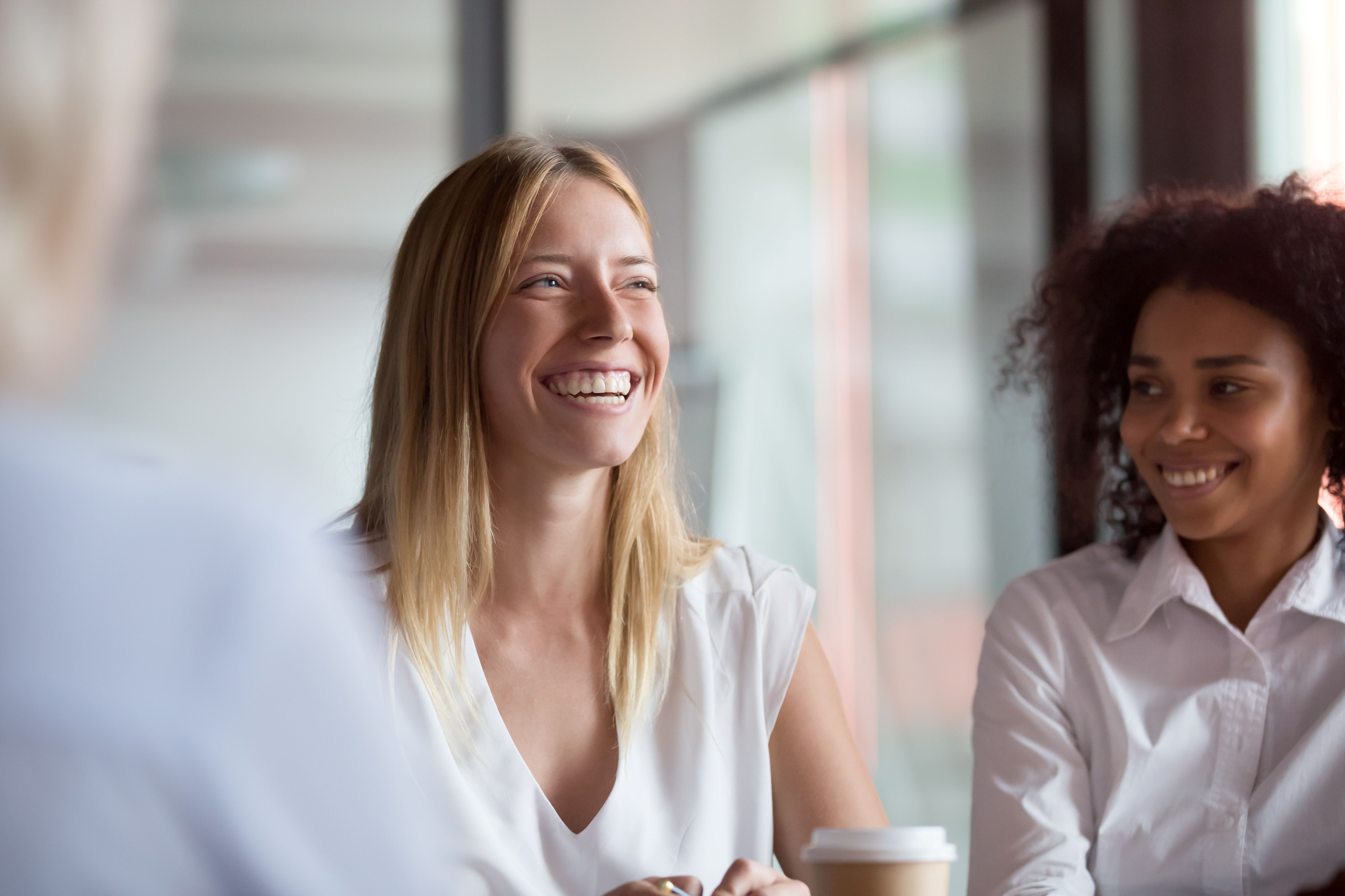 Two women are smiling side by side.