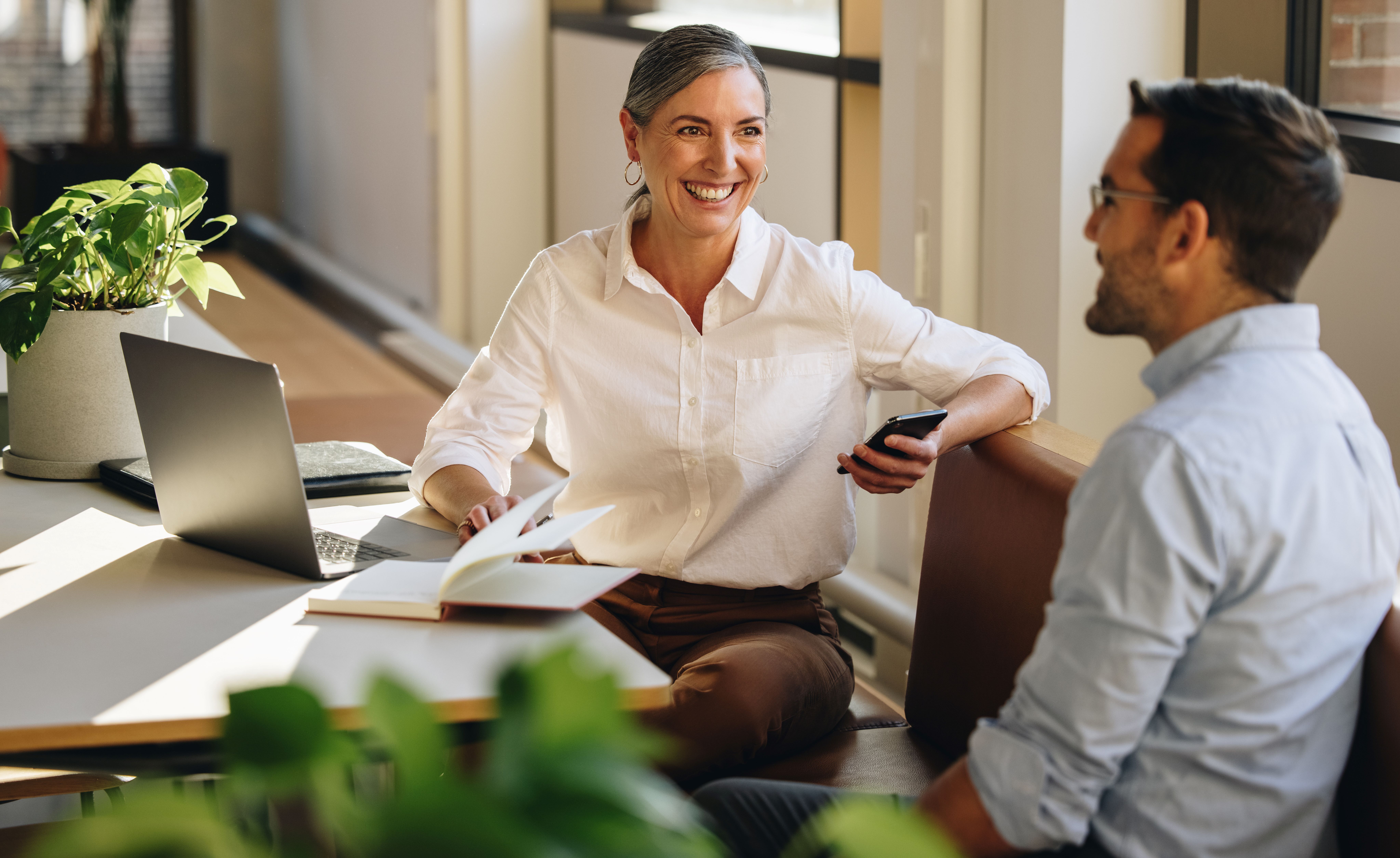 Woman and man are discussing around the table.